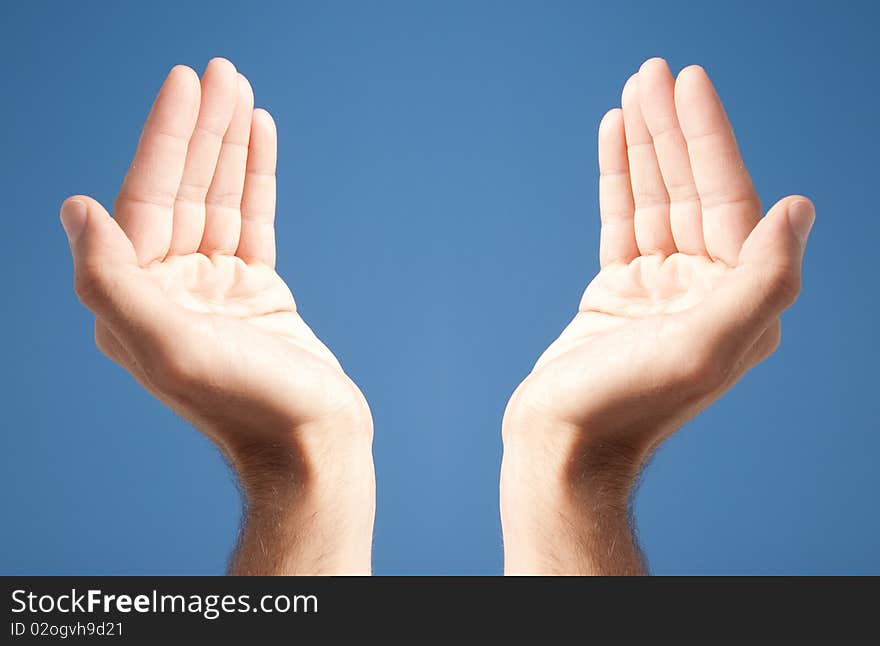 Two open white hands over blue background