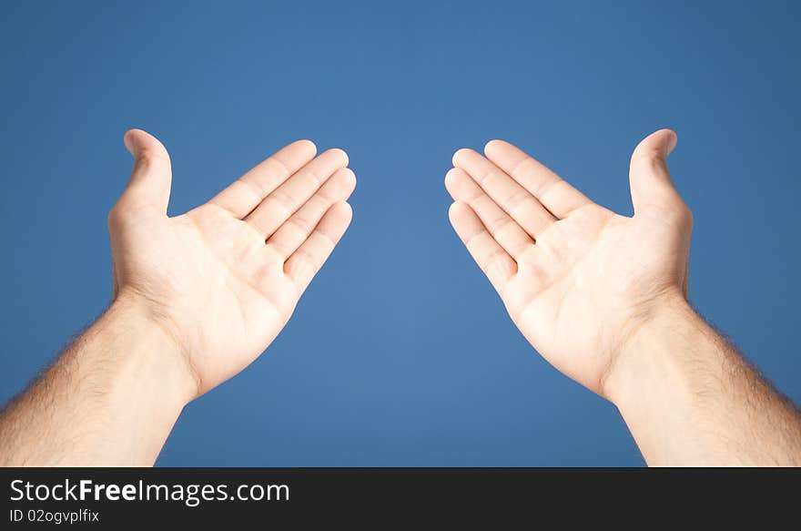 Two open white hands over blue background