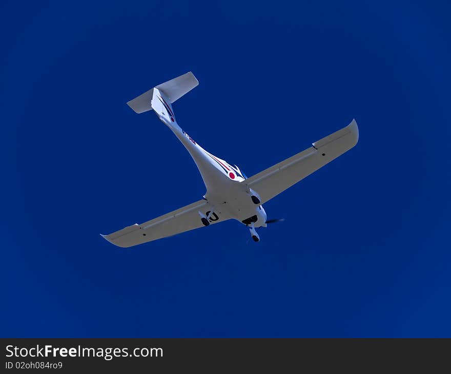 Small one engine airplane captured from the ground on clear blue sky. Small one engine airplane captured from the ground on clear blue sky.