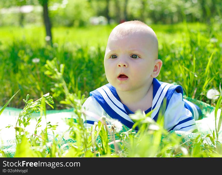 Small kid lays in a grass in park. Small kid lays in a grass in park