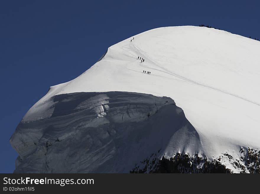 Tourists and sportsmen on the Breithorn mountain in the Swiss Alps. There is snow and in summer as well.