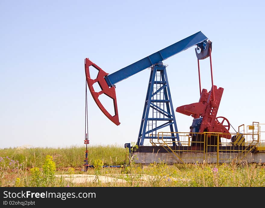 Oil field Pump Jack with a bright blue sky. Oil field Pump Jack with a bright blue sky