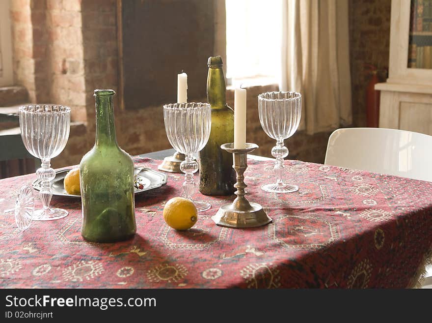 Table with bottles, candles and glasses. Table with bottles, candles and glasses