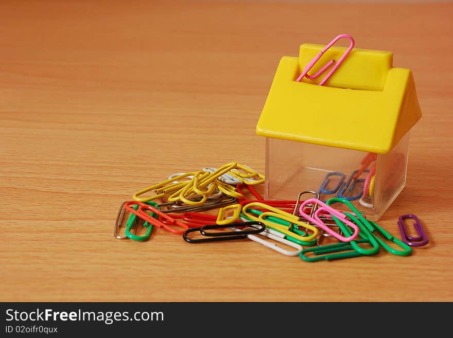 Paper clips with a  house shape container. Paper clips with a  house shape container