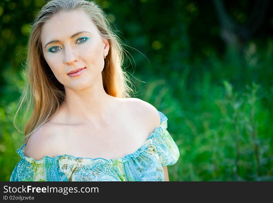 Beautiful woman among green leaves in the forest