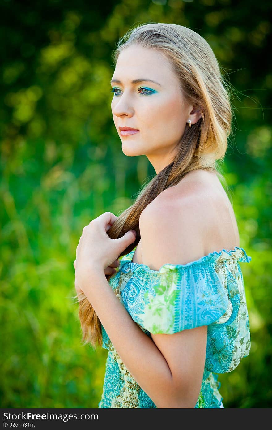 Woman among green leaves in the forest