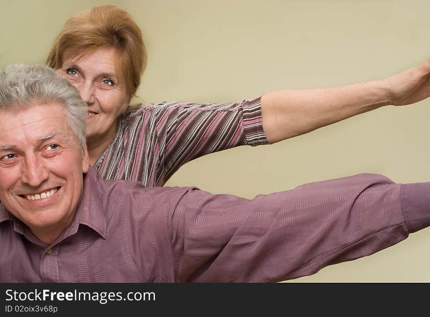 Happy elderly couple together on a green background