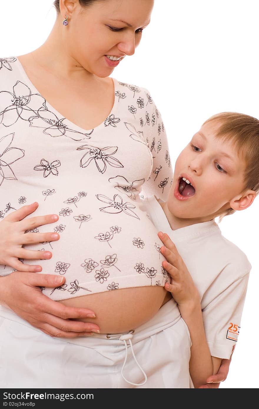 Son hugging his pregnant mothers stomach on a white. Son hugging his pregnant mothers stomach on a white