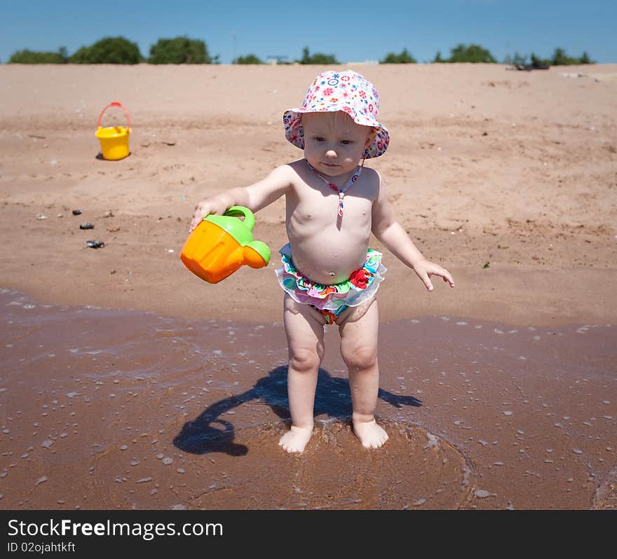 Image of the happy baby playing on the beach