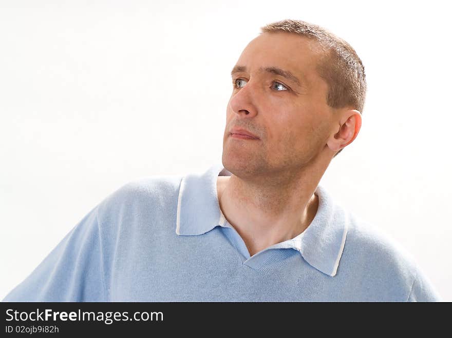 Man in a blue shirt standing on a white. Man in a blue shirt standing on a white