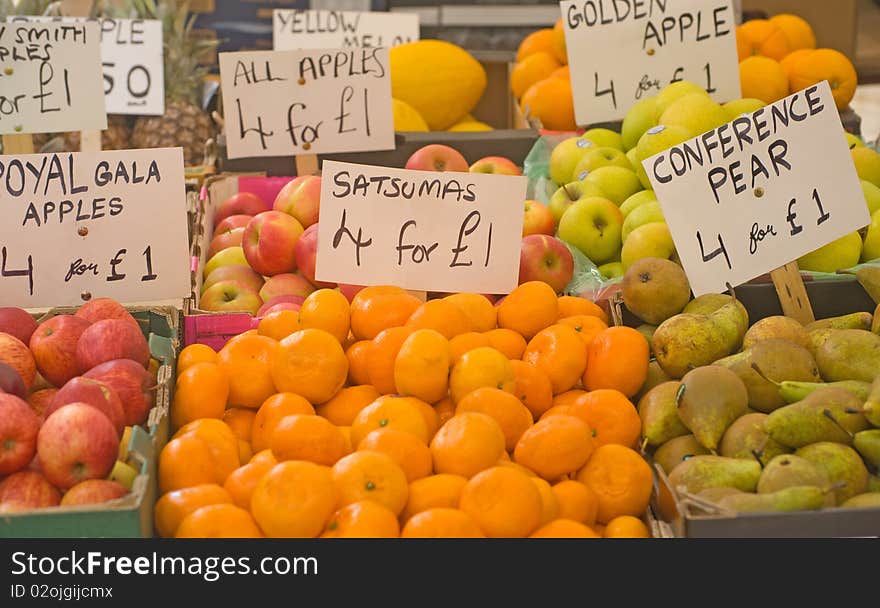 An image of fresh, organic fruits for sale on a market stall in England showing price labels. An image of fresh, organic fruits for sale on a market stall in England showing price labels.