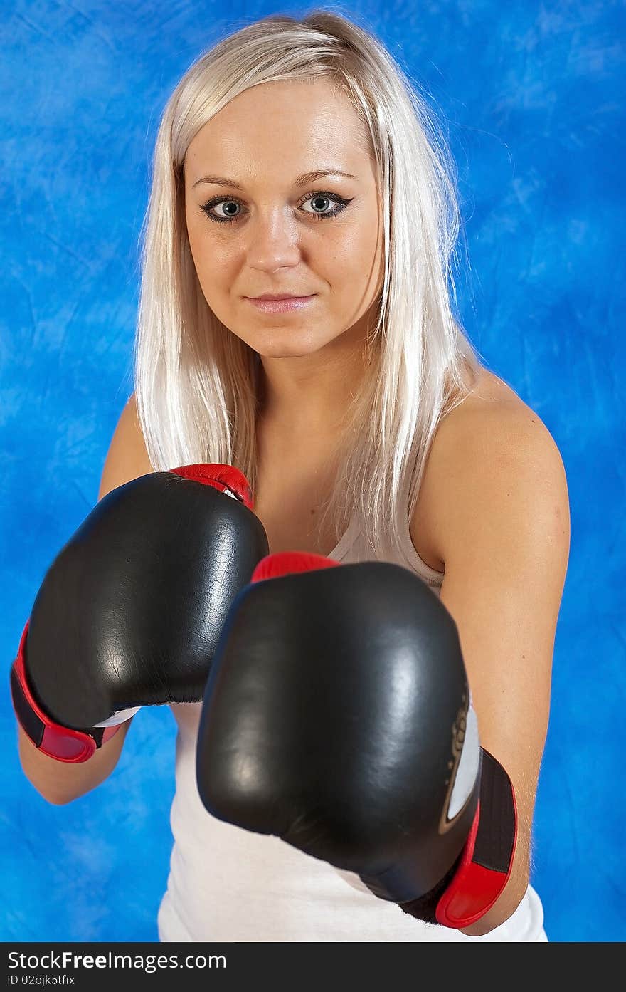 Young beautiful woman in boxing gloves on the blue mosaic background. Young beautiful woman in boxing gloves on the blue mosaic background