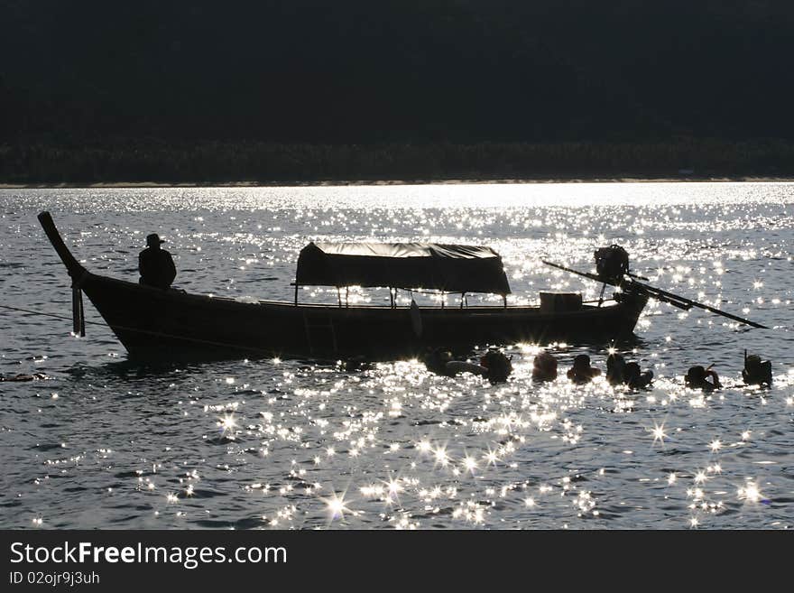 Tourist swimming to Skin drive near long tailboat. Tourist swimming to Skin drive near long tailboat