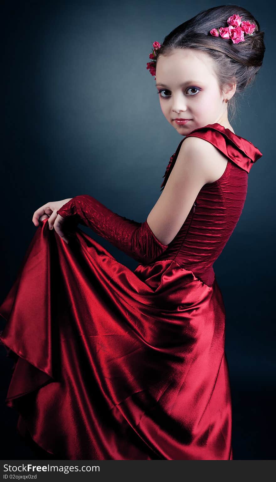 Young model in red dress posing on black background. Young model in red dress posing on black background