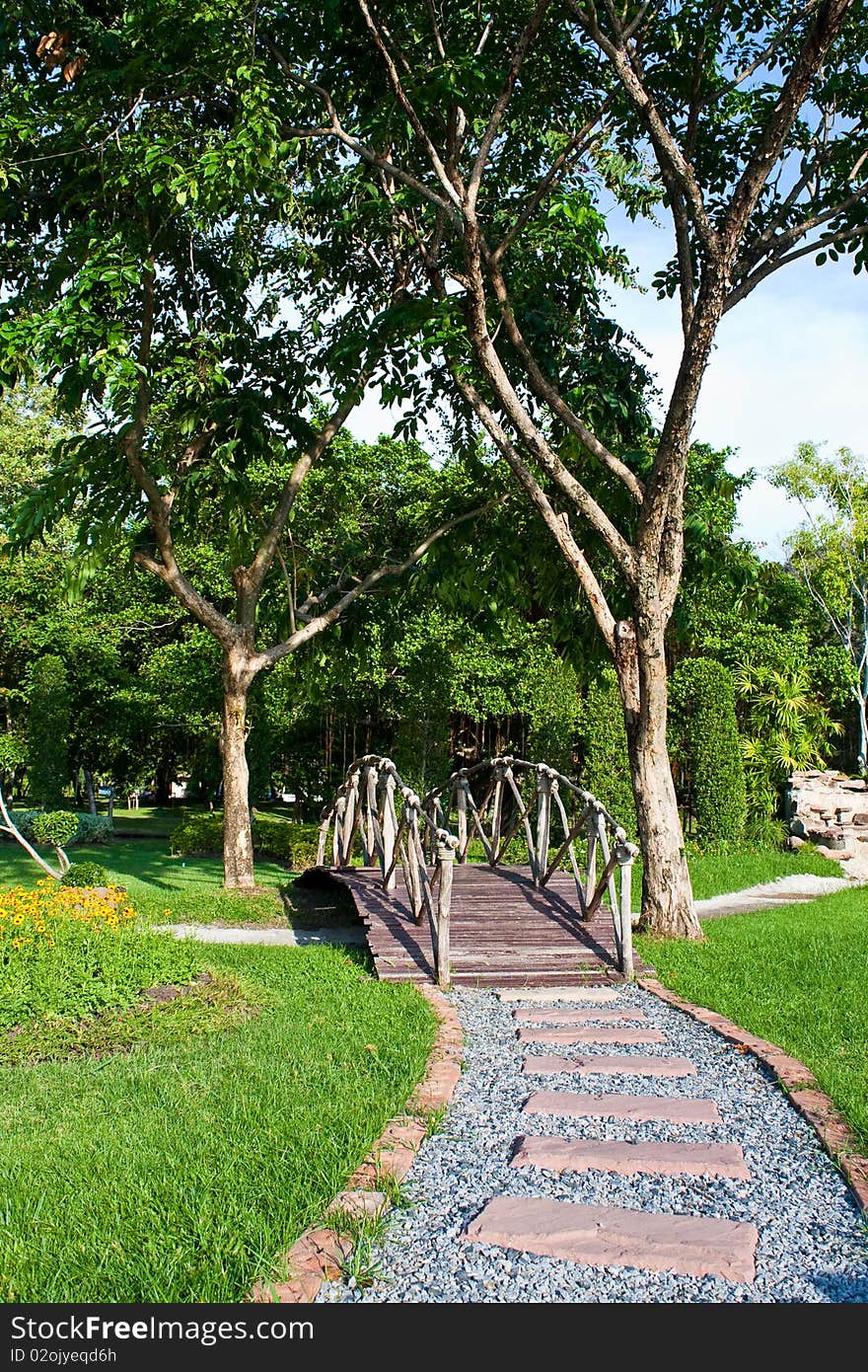 Stone walk way to wooden bridge in garden. Stone walk way to wooden bridge in garden