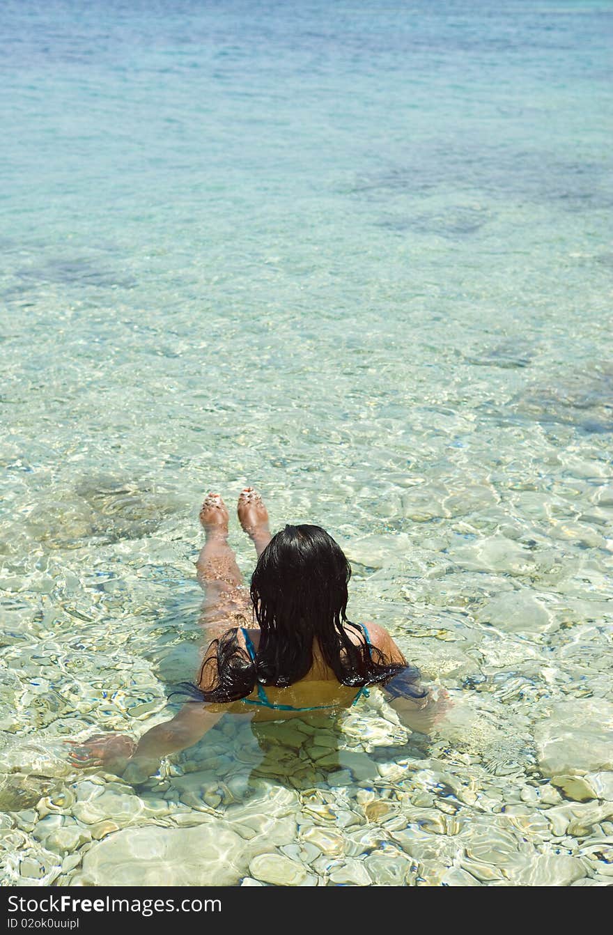 A color portrait photo of a beautiful woman relaxing in the clear blue sea of the ionian region in Greece. A color portrait photo of a beautiful woman relaxing in the clear blue sea of the ionian region in Greece