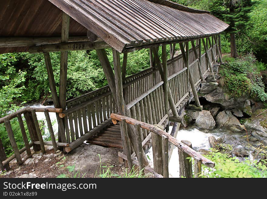 A wooden bridge along the riverside of Santantonio river, in Santantonio's Valley, Lombardy, Italy.