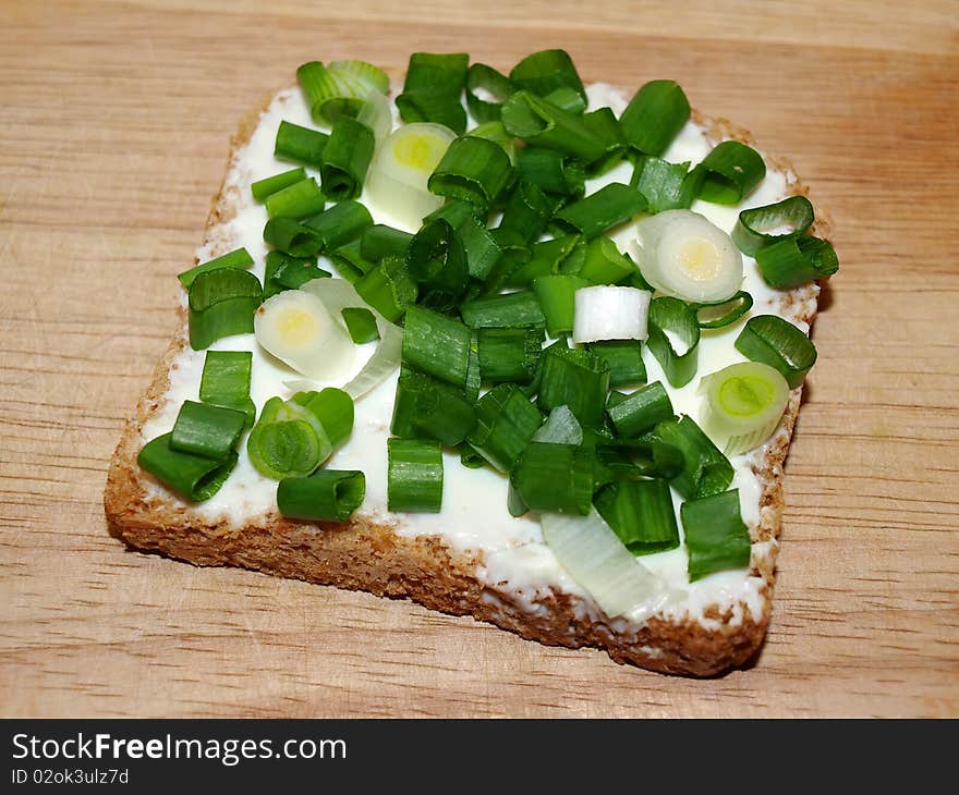 A slice of bread with green onion. A slice of bread with green onion.