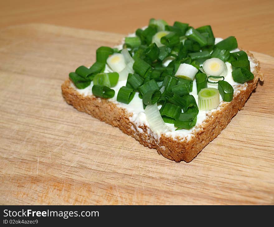 A slice of bread with green onion. A slice of bread with green onion.