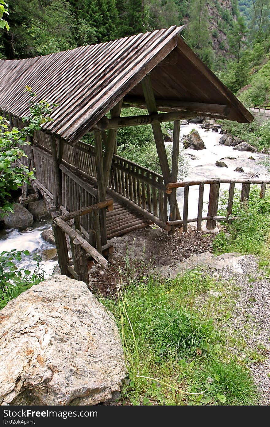 A wooden bridge along the riverside of Santantonio river, in Santantonio's Valley, Lombardy, Italy.