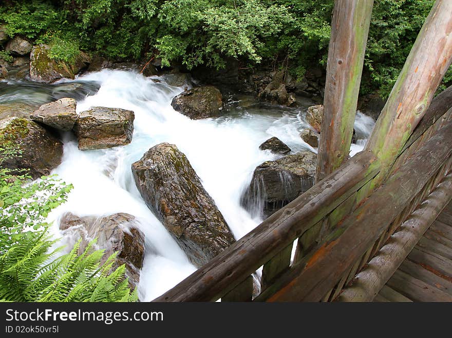 A wooden bridge along the riverside of Santantonio river, in Santantonio's Valley, Lombardy, Italy.