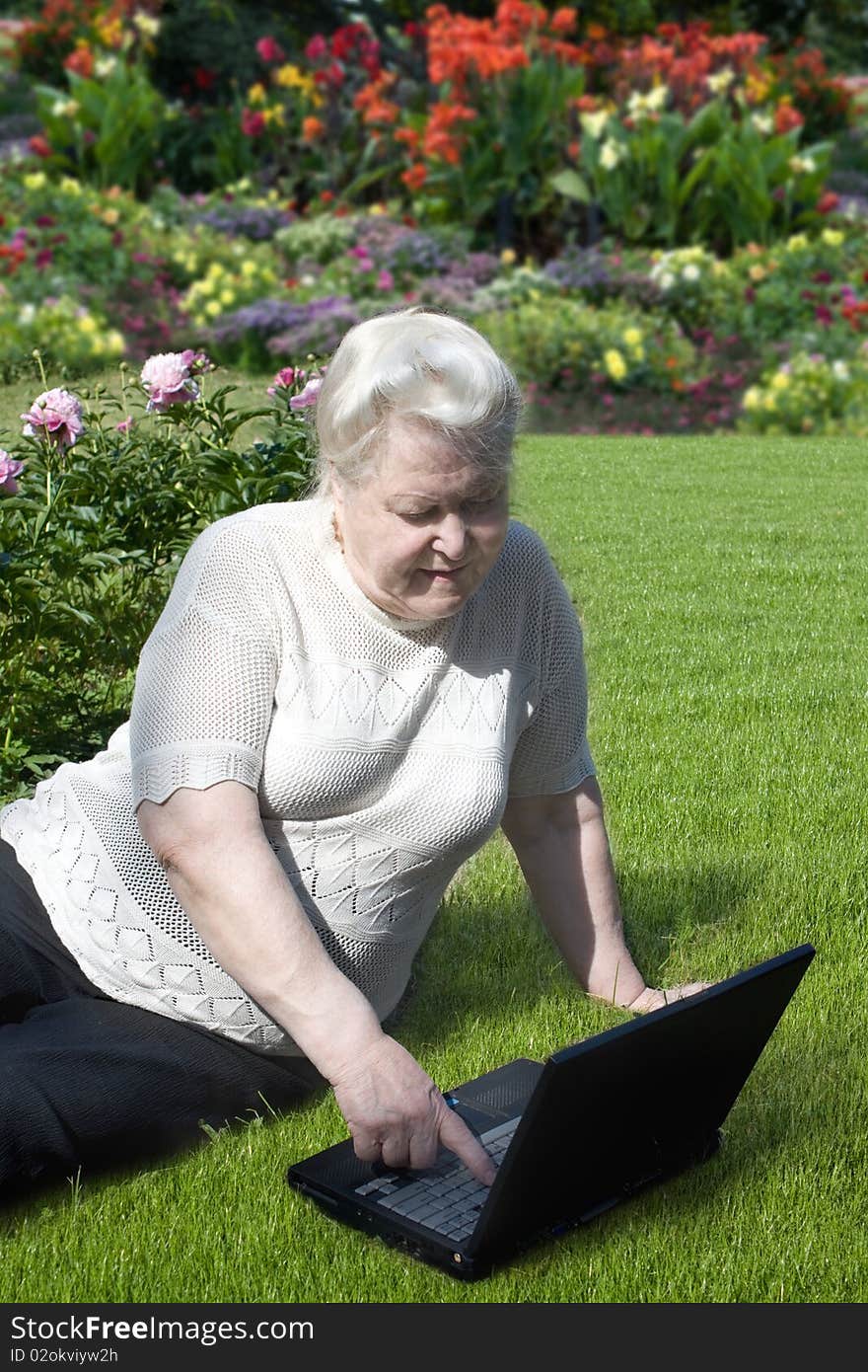 Senior woman with laptop in the garden. Senior woman with laptop in the garden.