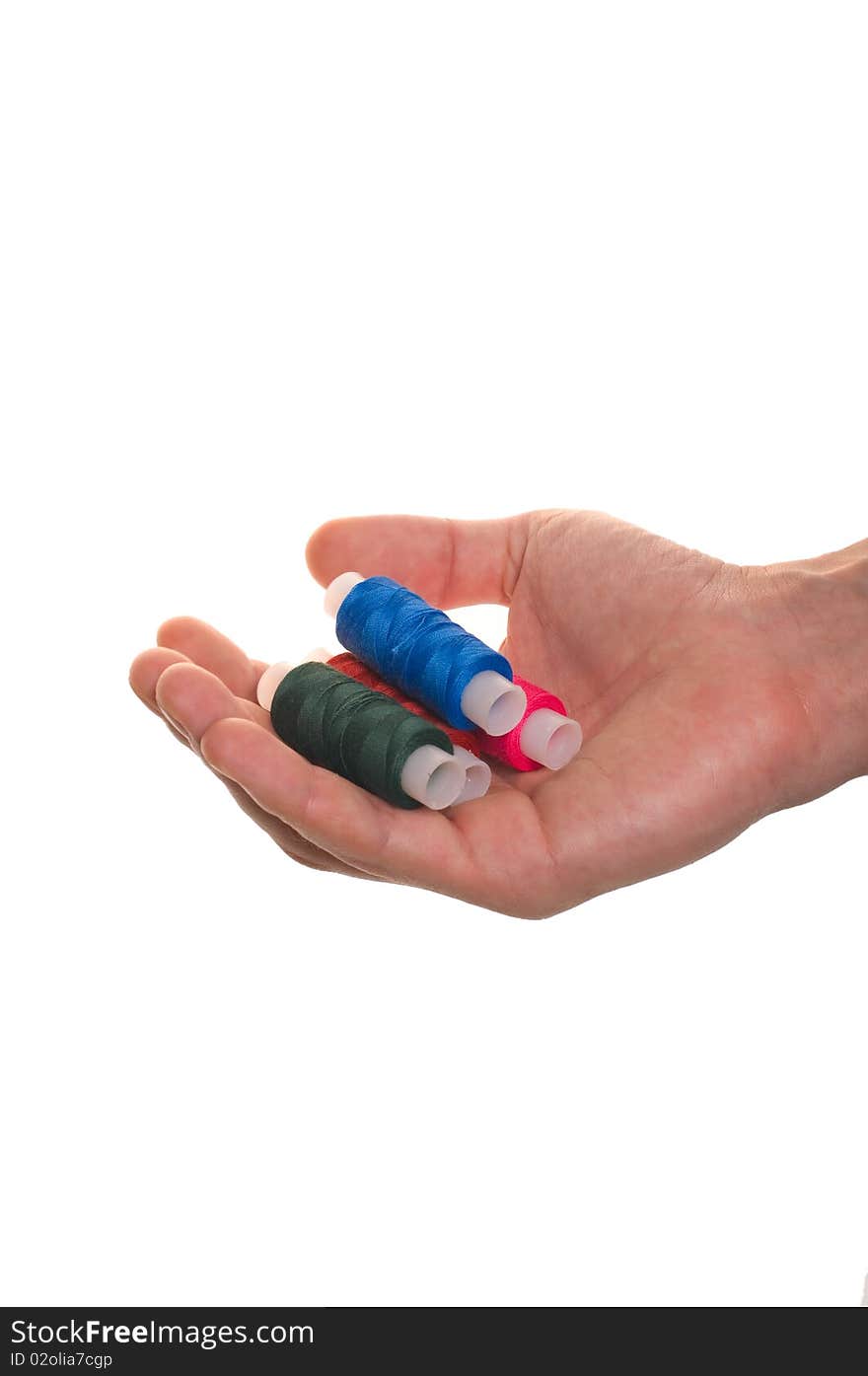 Hand holds the spool of thread for sewing isolated over white