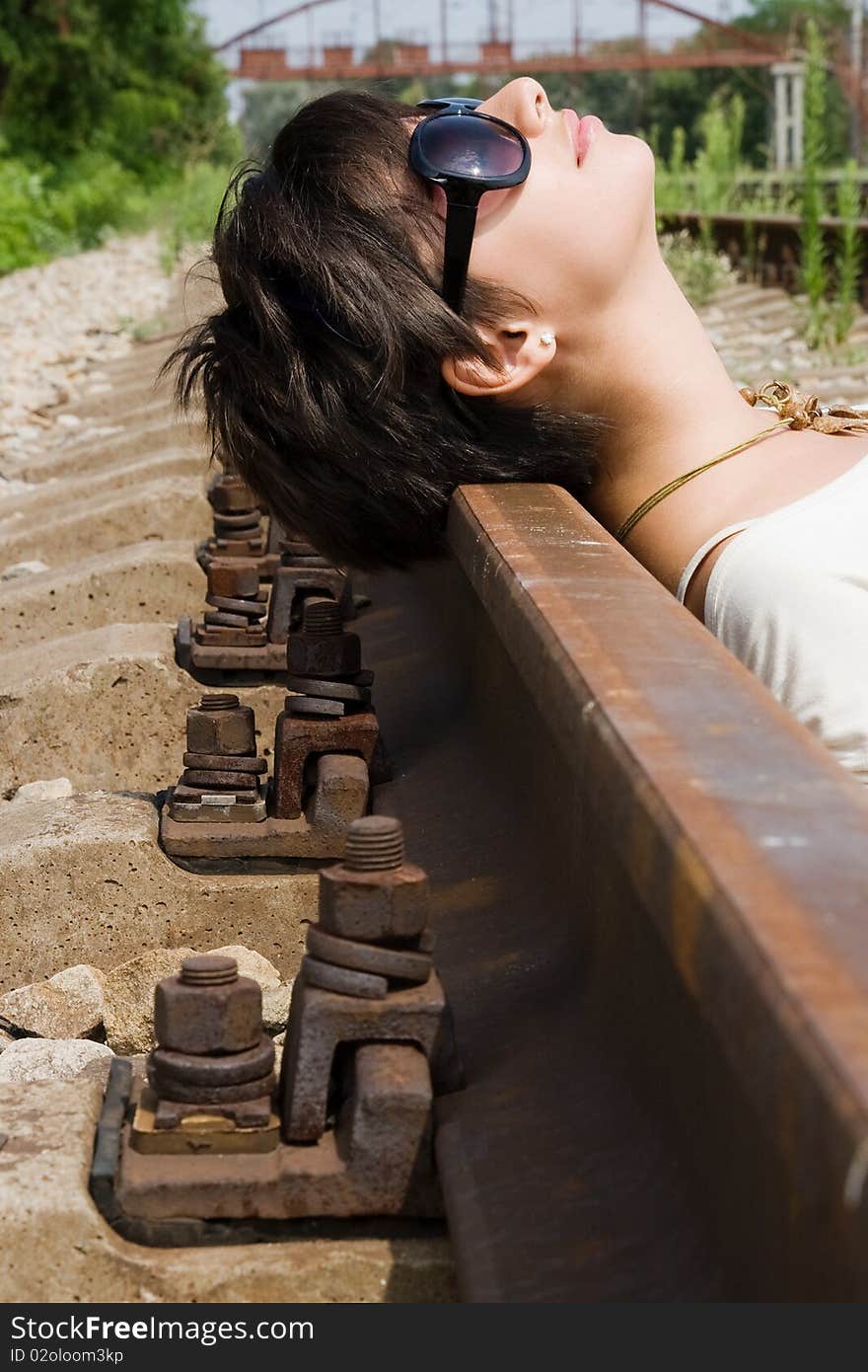 Young attractive brunette lying on the railway carelessly. Young attractive brunette lying on the railway carelessly