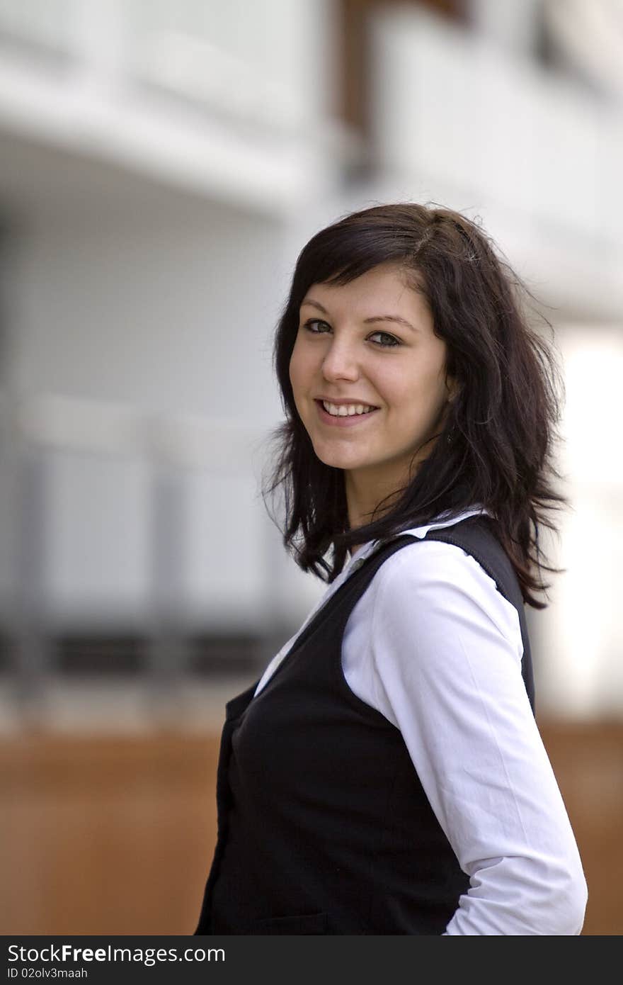 Smiling and good looking business woman in front of a modern business building. Smiling and good looking business woman in front of a modern business building