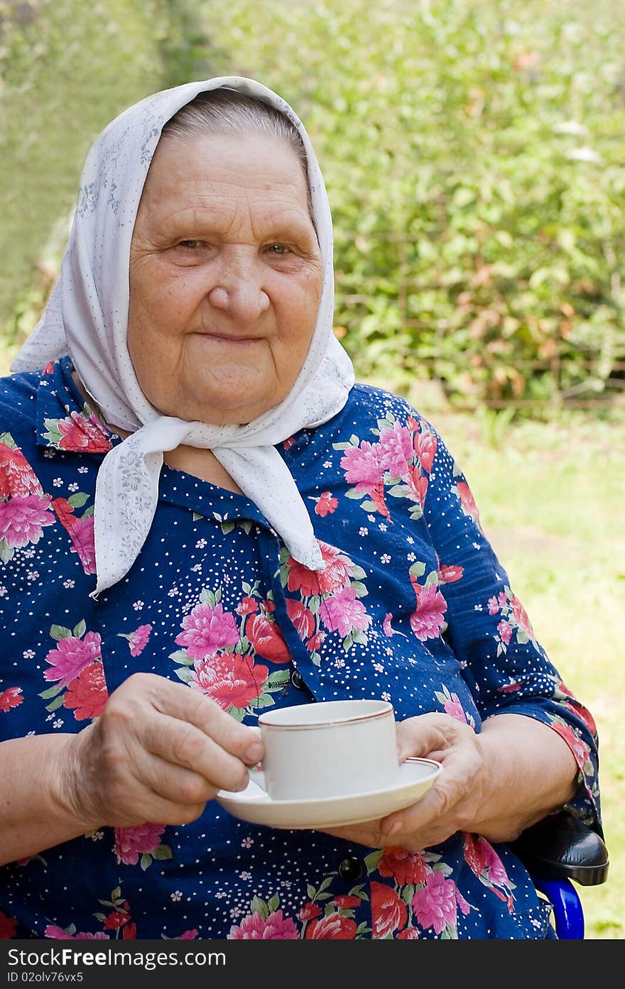 Portrait of the old woman drinking tea