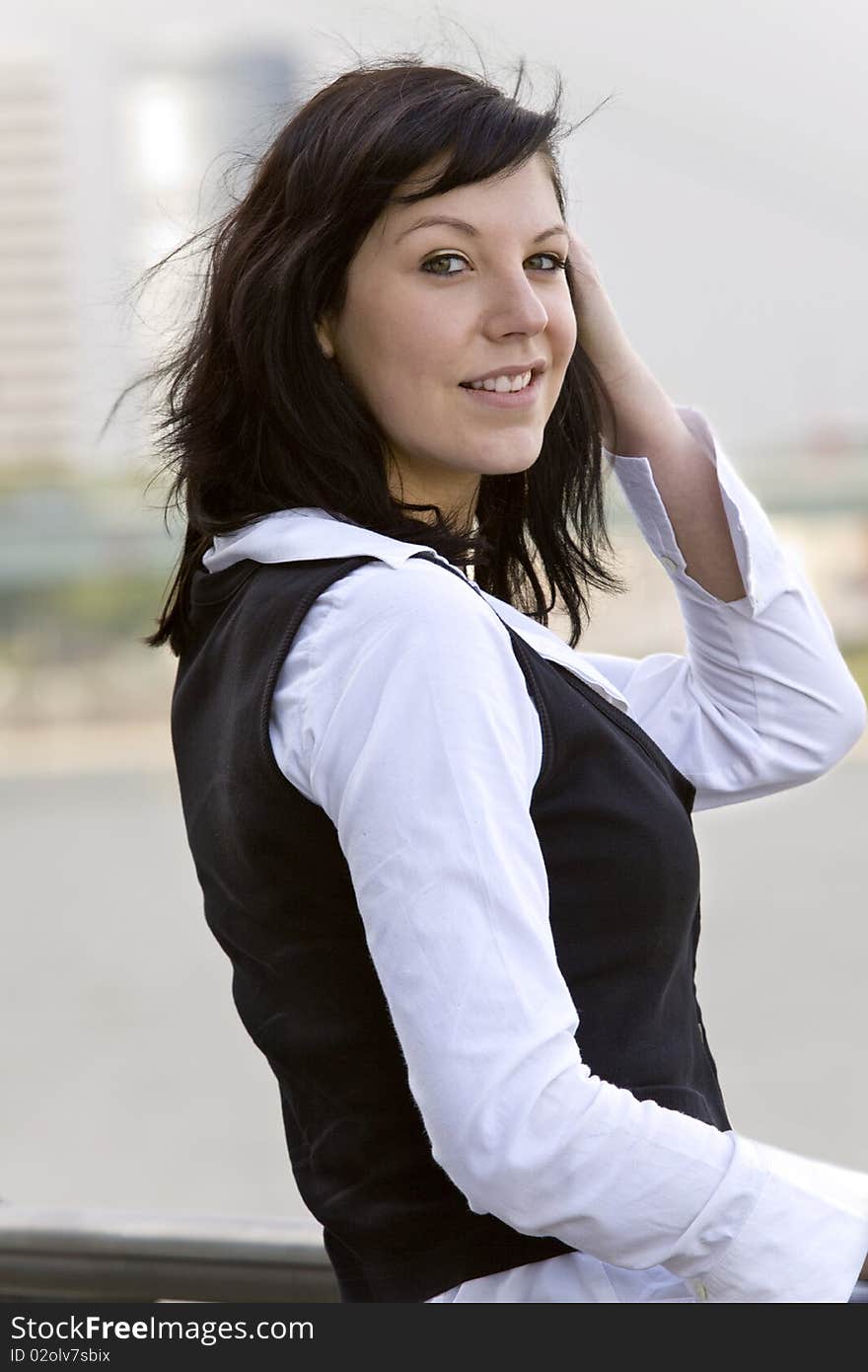 Smiling and good looking business woman in front of a modern business building. Smiling and good looking business woman in front of a modern business building