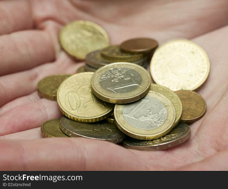 Handful of euro coins in women's hands