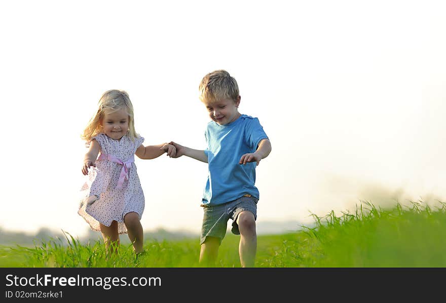 Brother and sister playing together in a field. Brother and sister playing together in a field