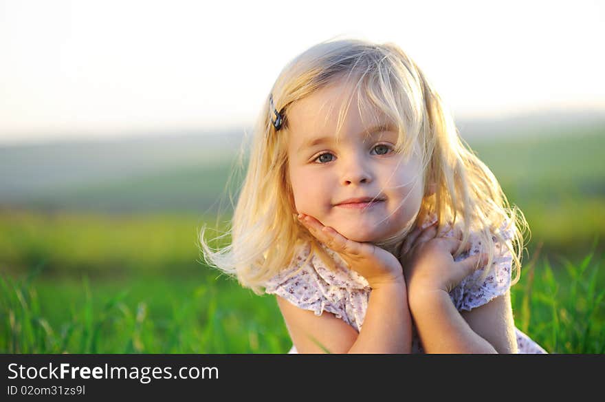 Beautiful blonde girl outside in a field with sunlight on her hair. Beautiful blonde girl outside in a field with sunlight on her hair.