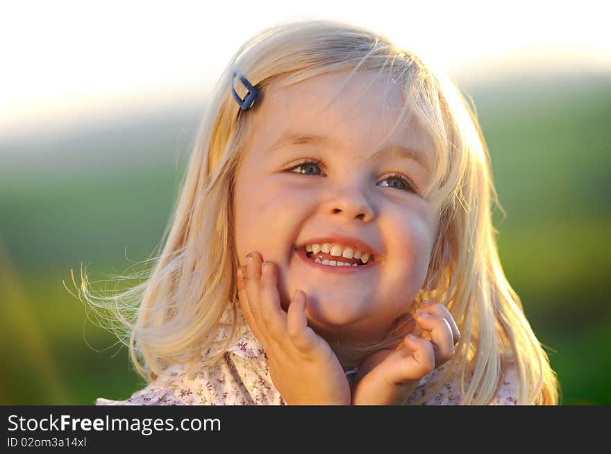 Beautiful blonde girl outside in a field with sunlight on her hair. Beautiful blonde girl outside in a field with sunlight on her hair.