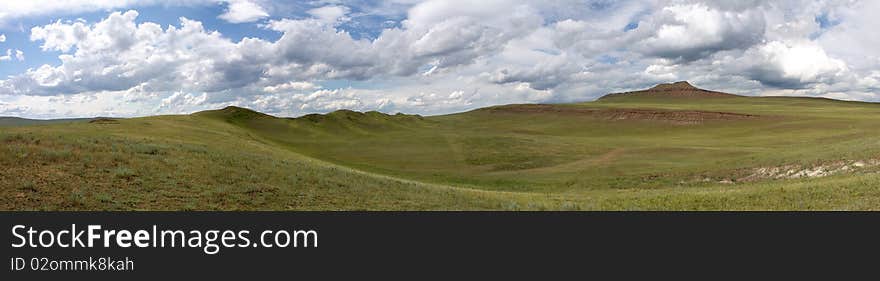 Green grass in mountains, grey cumulus clouds foretell a thunder-storm. Green grass in mountains, grey cumulus clouds foretell a thunder-storm