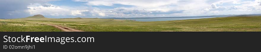 green grass in mountains, grey cumulus clouds foretell a thunder-storm. green grass in mountains, grey cumulus clouds foretell a thunder-storm