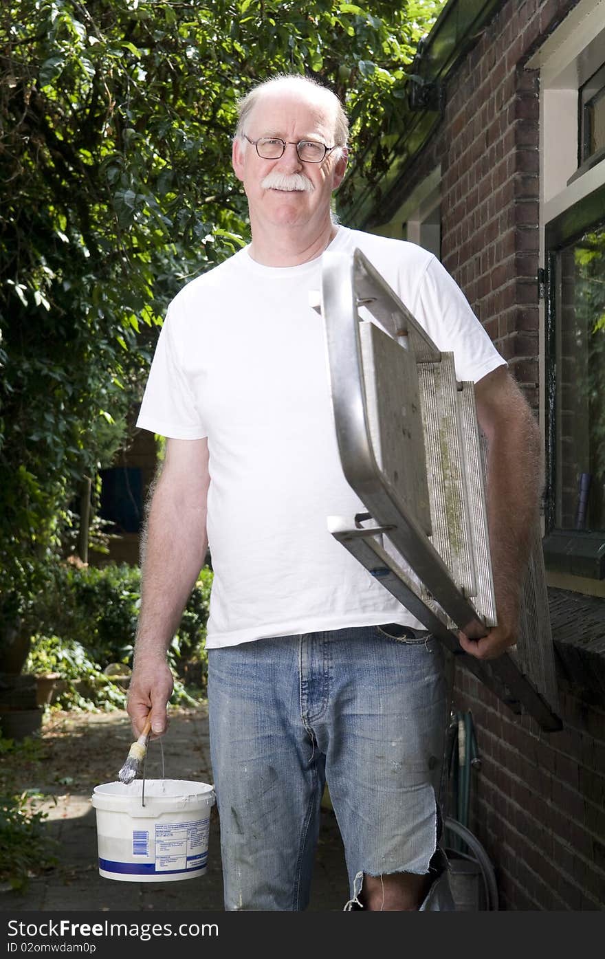 Portrait of a painter outside with ladder and paint