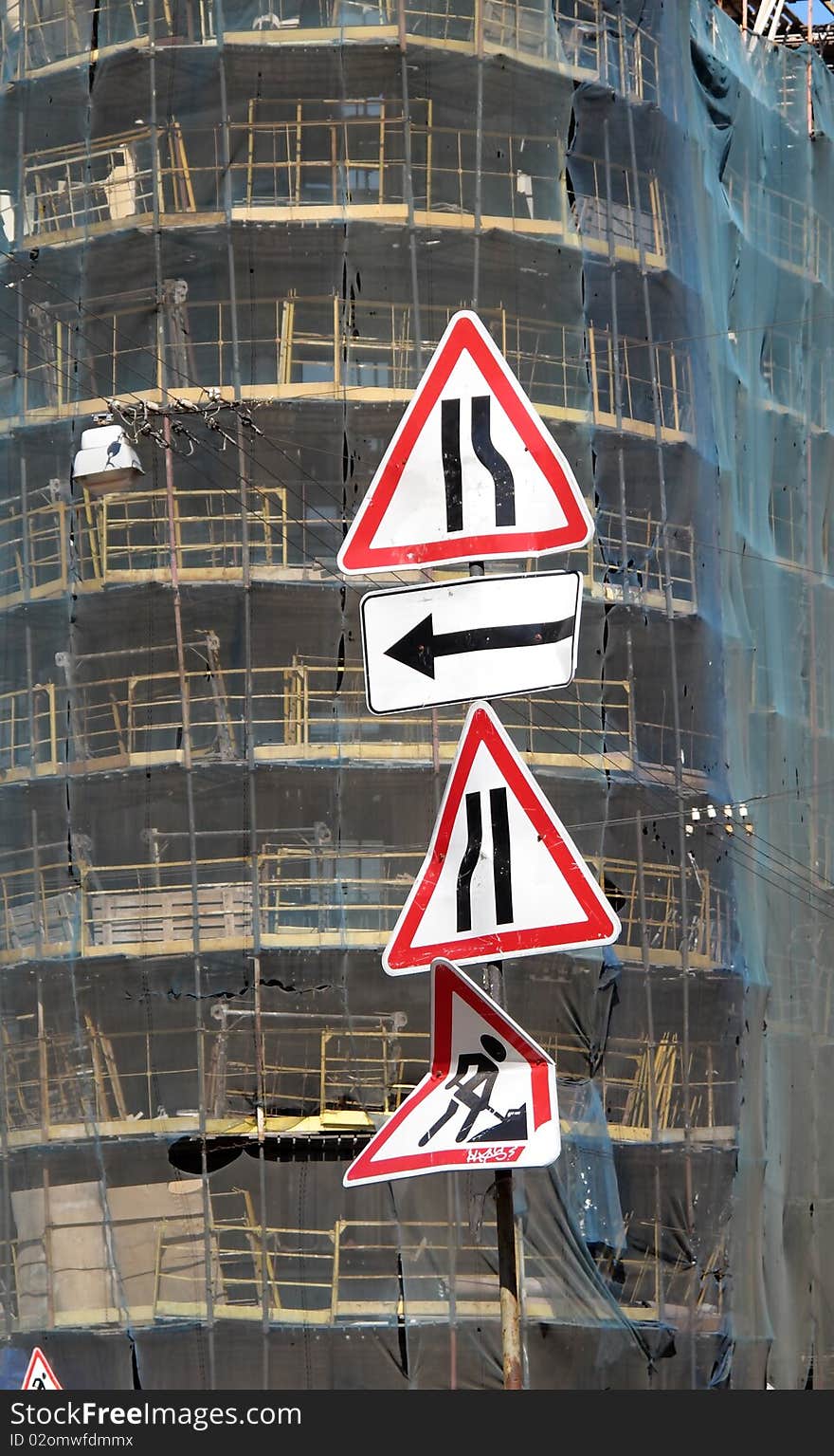 Four traffic signs against the old house