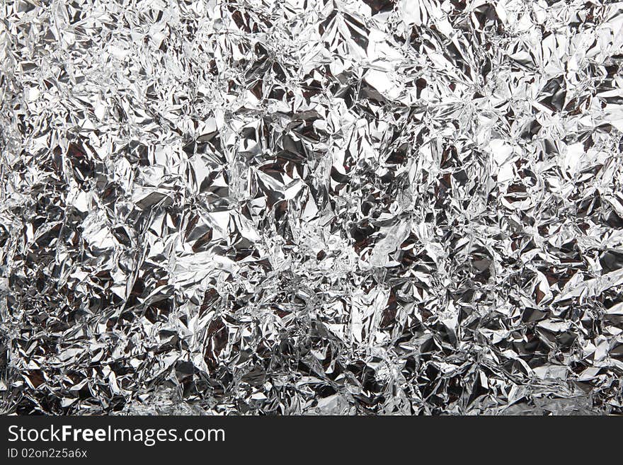 Abstract crumpled silver aluminum foil closeup background texture, in withe