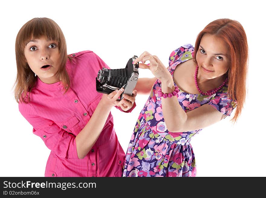 Two girls look with surprise on analog camera