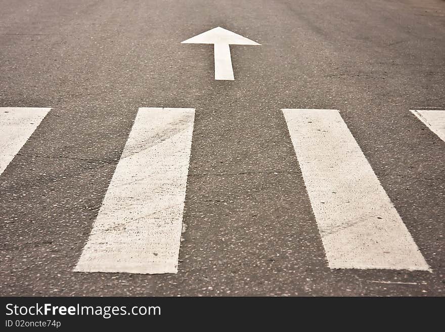 Pedestrian crossing an arrow on the road at day. Pedestrian crossing an arrow on the road at day