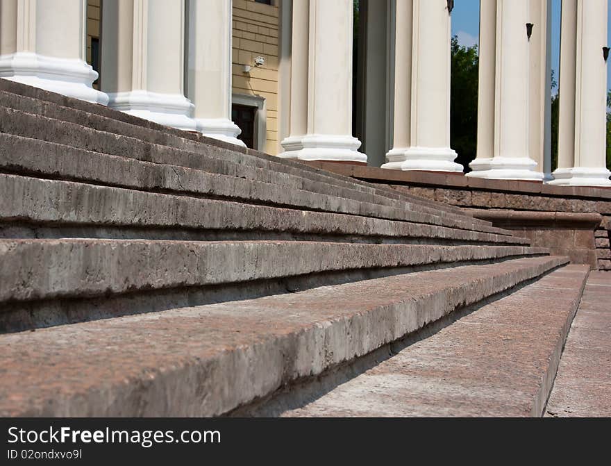 Old stone broken staircase and white pillars