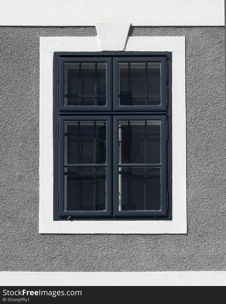 Window on a house with gray wall