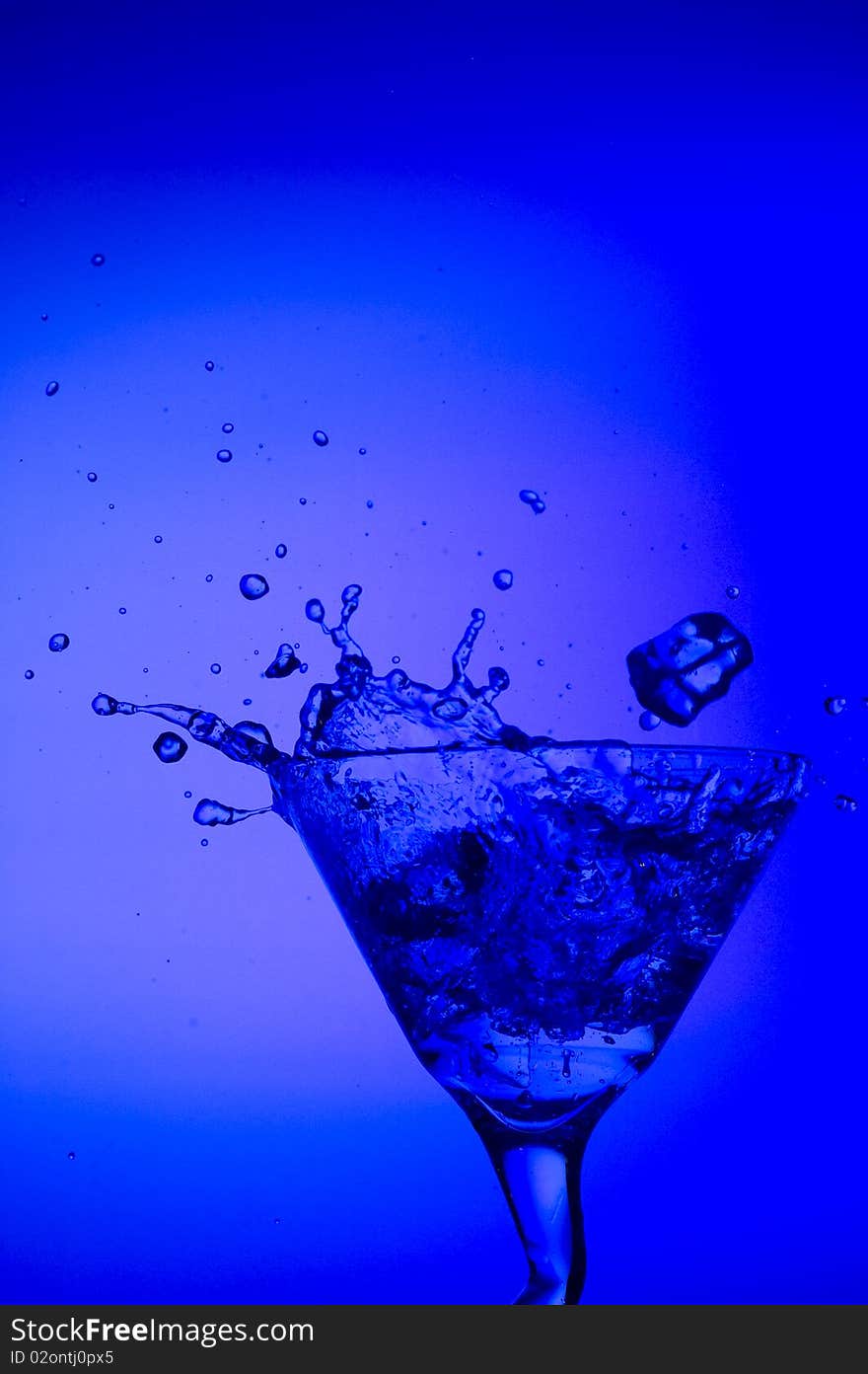 Splashing cocktail on the blue background