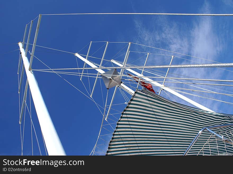 Looking up on must of sailing yacht on blue sky background. Looking up on must of sailing yacht on blue sky background