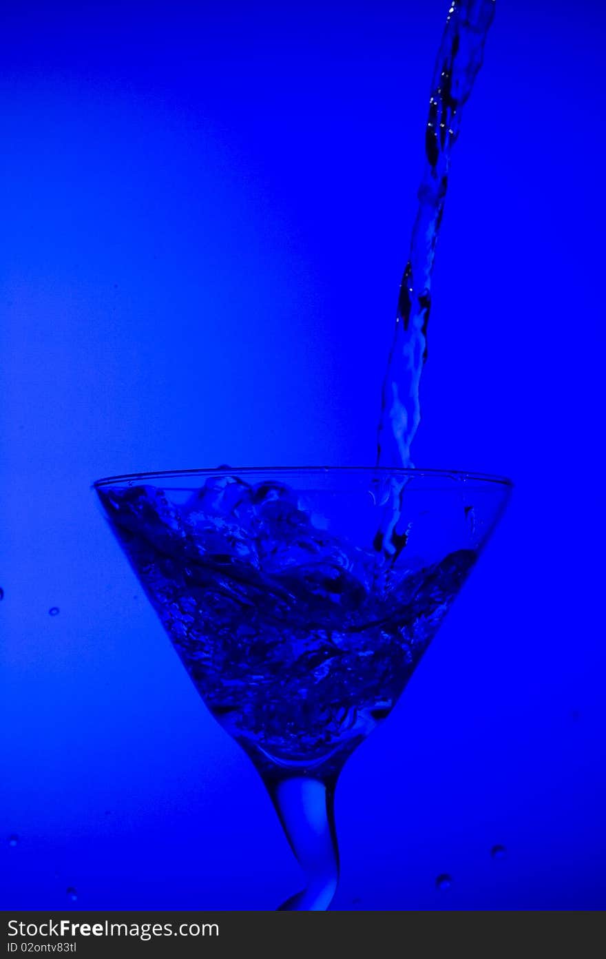 Splashing cocktail on the blue background