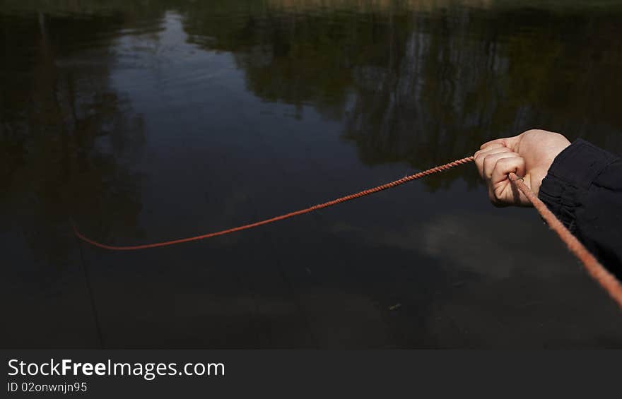 Hand firefighter, who monitors the diver on a rope. Diver looking for sunken car in the river Elbe. Czech Republic. Hand firefighter, who monitors the diver on a rope. Diver looking for sunken car in the river Elbe. Czech Republic