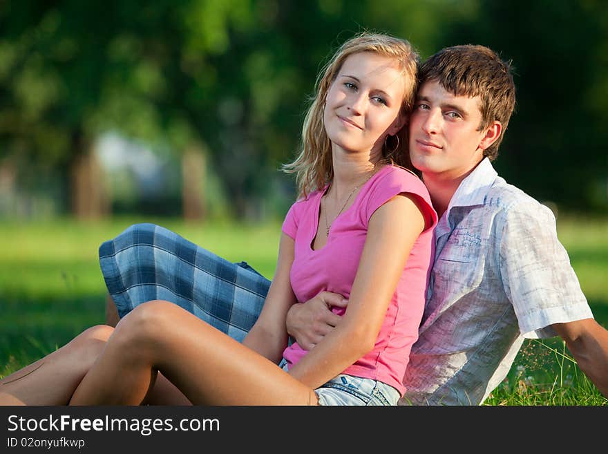 Couple resting on the grass in the park