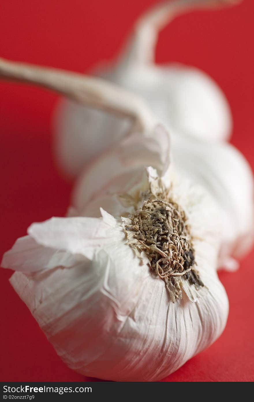 Garlic cloves on red background. Garlic cloves on red background